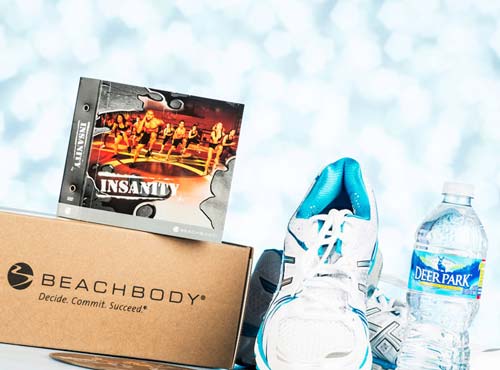 Beachbody logo'd box with DVD set, pair of running shoes and bottled water